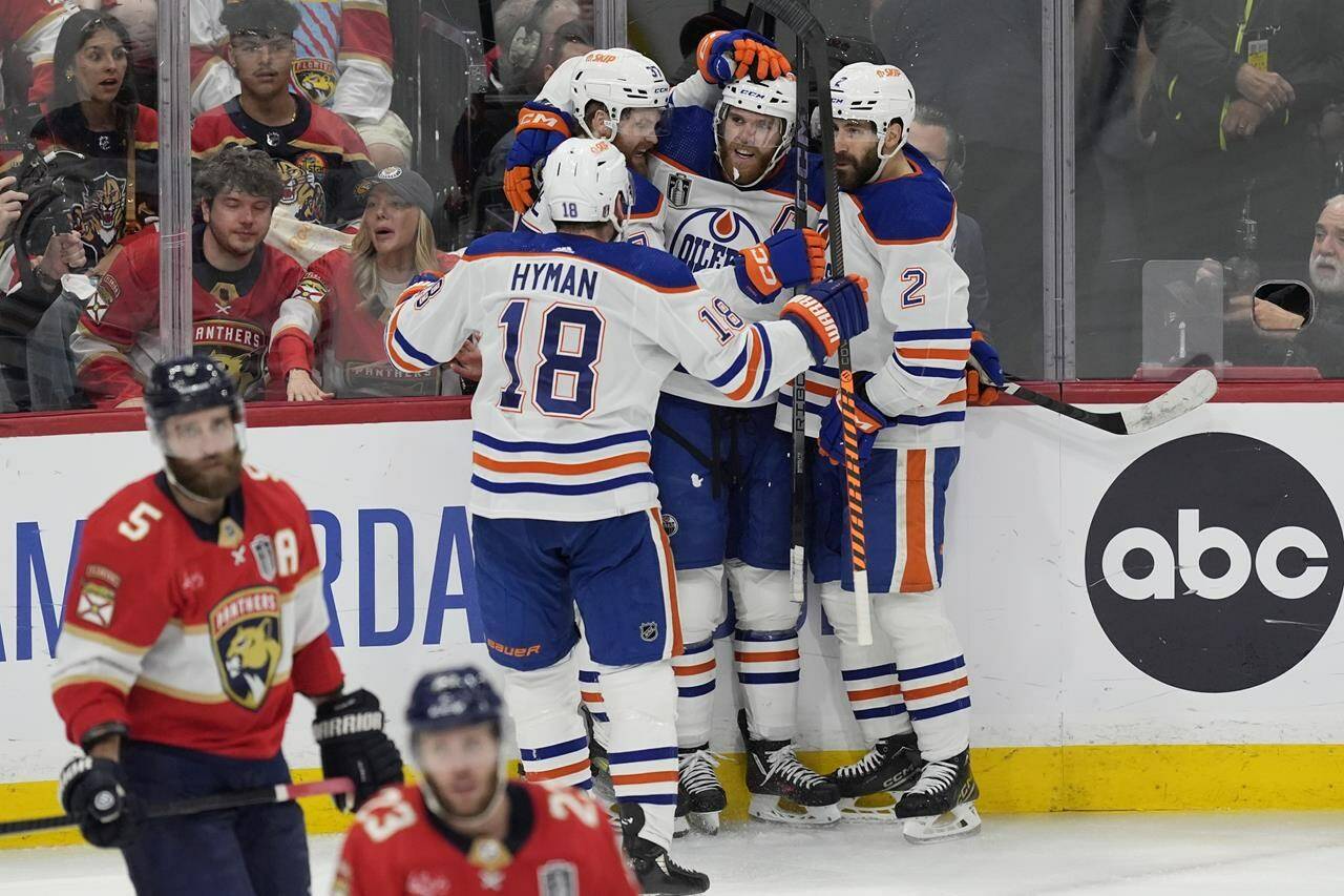 Edmonton Oilers centre Connor McDavid (97), is congratulated by his teammates after scoring a goal during the second period of Game 5 of the NHL hockey Stanley Cup final against the Florida Panthers, Tuesday, June 18, 2024, in Sunrise, Fla. (AP Photo/Rebecca Blackwell)