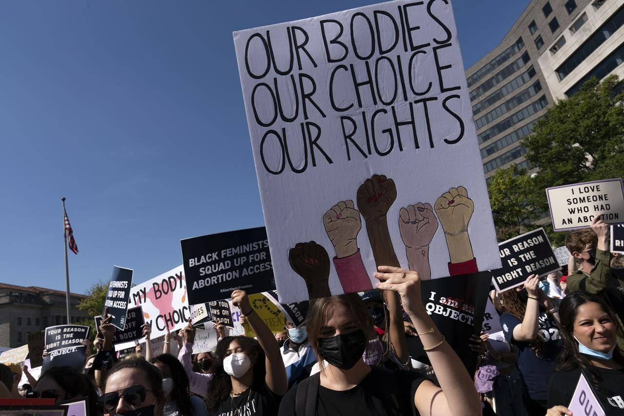 Activists hold signs during the Women’s March rally at Freedom Plaza, in Washington, Saturday, Oct. 2, 2021. (AP Photo/Jose Luis Magana)