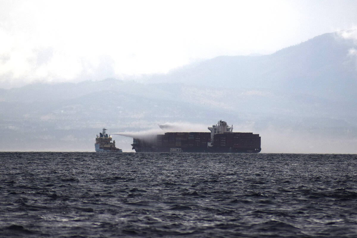 A tug boat sprays the hull of the M/V Zim Kingston at 9:50 a.m., Sunday, Oct. 24. (Kiernan Green/News Staff)