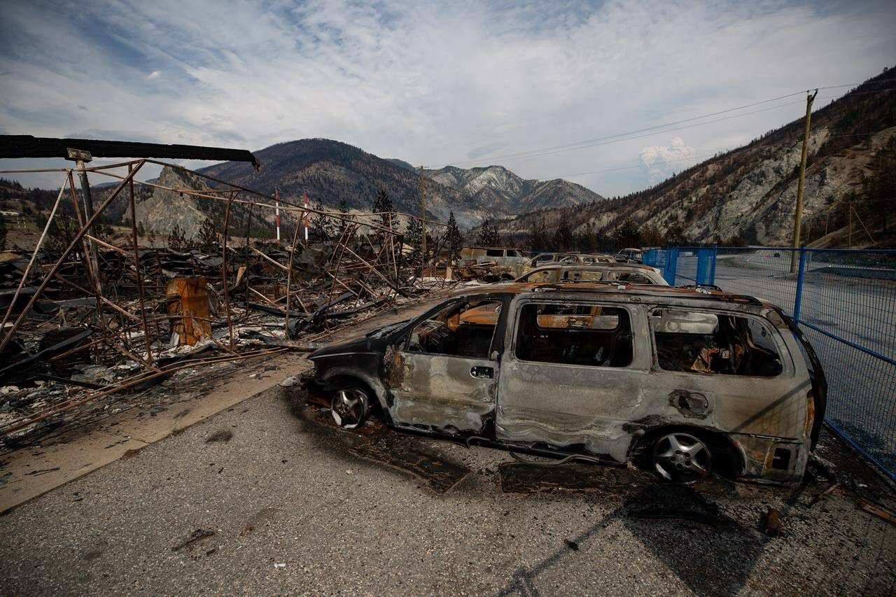 The remains of a large structure and vehicles destroyed by the Lytton Creek wildfire are seen on the side of the Trans-Canada Highway near Lytton, B.C., on Sunday, Aug. 15, 2021. B.C.’s public safety ministry has announced the appointment of two parliamentary secretaries who will work as recovery liaisons between the province and the village of Lytton following a wildfire earlier this year. THE CANADIAN PRESS/Darryl Dyck