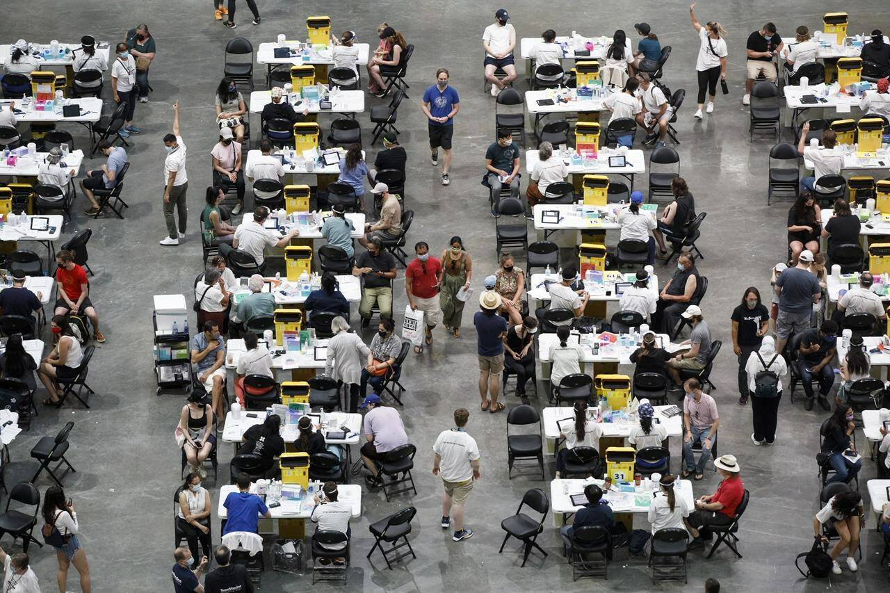 People receive a dose of the COVID-19 vaccine at a mass vaccination clinic at Scotiabank Arena in Toronto on Sunday, June 27, 2021. THE CANADIAN PRESS/Cole Burston