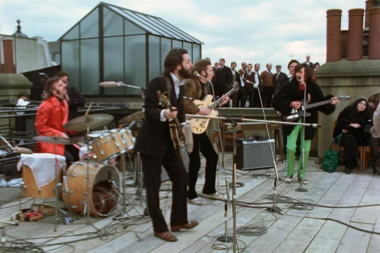 This image released by Disney+ shows, from left, Ringo Starr, Paul McCartney, John Lennon and George Harrison, with Yoko Ono, seated right, in a scene from the nearly 8-hour Peter Jackson-produced documentary “Get Back,” airing over three days starting Thanksgiving. (Disney+ via AP)