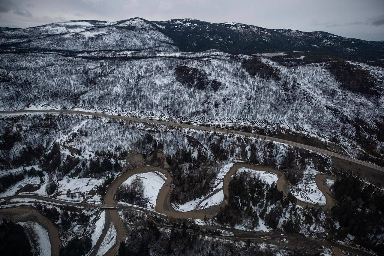 Trees burned in this summer’s wildfires are seen on a mountainside covered with snow as the Coldwater River snakes along side the Coquihalla Highway south of Merritt, B.C., in an aerial view from a Canadian Forces reconnaissance flight on Monday, November 22, 2021. THE CANADIAN PRESS/Darryl Dyck