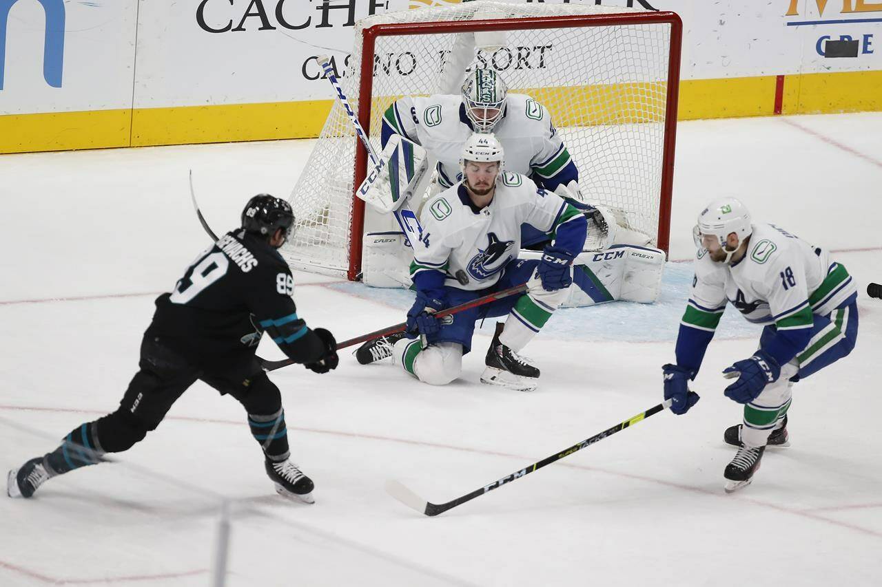 Vancouver Canucks defenceman Kyle Burroughs (44) blocks a shot against San Jose Sharks left wing Jayden Halbgewachs (89) during the first period of an NHL hockey game Thursday, Dec. 16, 2021, in San Jose, Calif. (AP Photo/Josie Lepe)