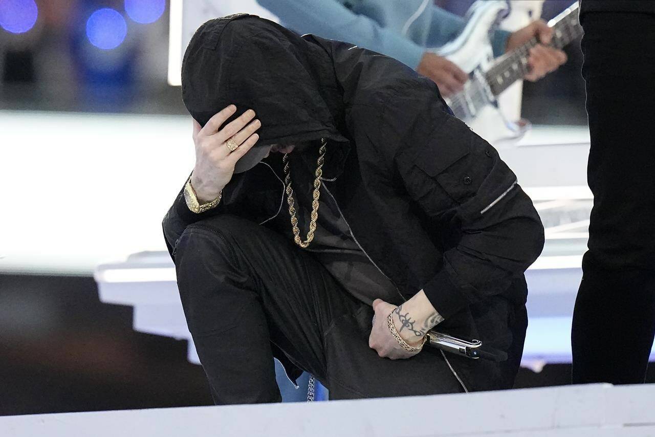 Eminem kneels down during the halftime performance at the NFL Super Bowl 56 football game between the Los Angeles Rams and the Cincinnati Bengals Sunday, Feb. 13, 2022, in Inglewood, Calif. (AP Photo/Chris O’Meara)