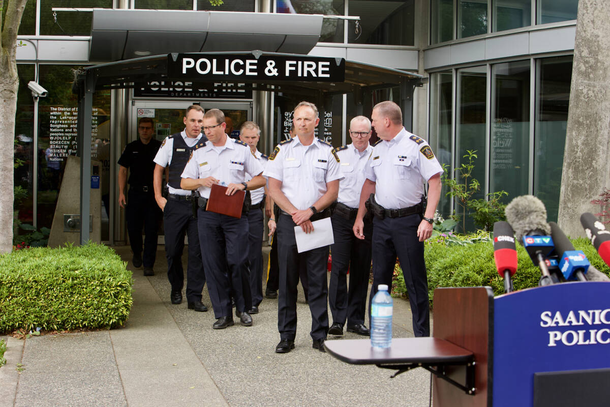 Members of Greater Victoria police forces, including Saanich Police Department Chief Dean Duthie, approach a podium Wednesday (June 29) to provide an update on the investigation into a bank robbery in Saanich Tuesday (June 28) which left two suspects dead and six police officers injured. (Justin Samanski-Langille/News Staff)