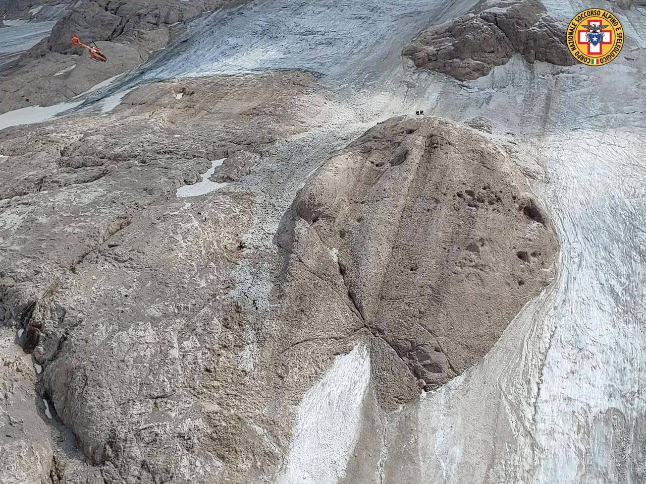 This image released on Sunday, July 3, 2022, by the Italian National Alpine and Cave Rescue Corps shows the glacier in Italy’s Alps near Trento a large chunk of which has broken loose, killing at least six hikers and injuring eight others. Alpine rescue service officials, which provided that toll Sunday evening, said it could take hours to determine if any hikers might be missing. The National Alpine and Cave Rescue Corps tweeted that the search of the involved area of Marmolada peak involved at least five helicopters and rescue dogs. (Corpo Nazionale Soccorso Alpino e Speleologico via AP)