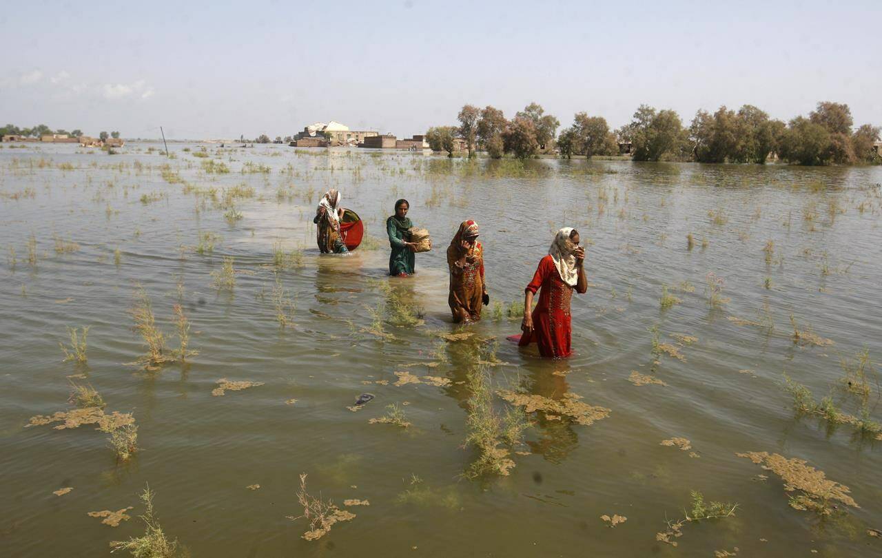 Pakistani women wade through floodwaters as they take refuge in Shikarpur district of Sindh province of Pakistan on Sep. 2, 2022. Pakistani health officials on Thursday reported an outbreak of waterborne diseases in areas hit by recent record-breaking flooding, as authorities stepped up efforts to ensure the provision of clean drinking water to hundreds of thousands of people who lost their homes in the disaster. THE CANADIAN PRESS/AP-Fareed Khan