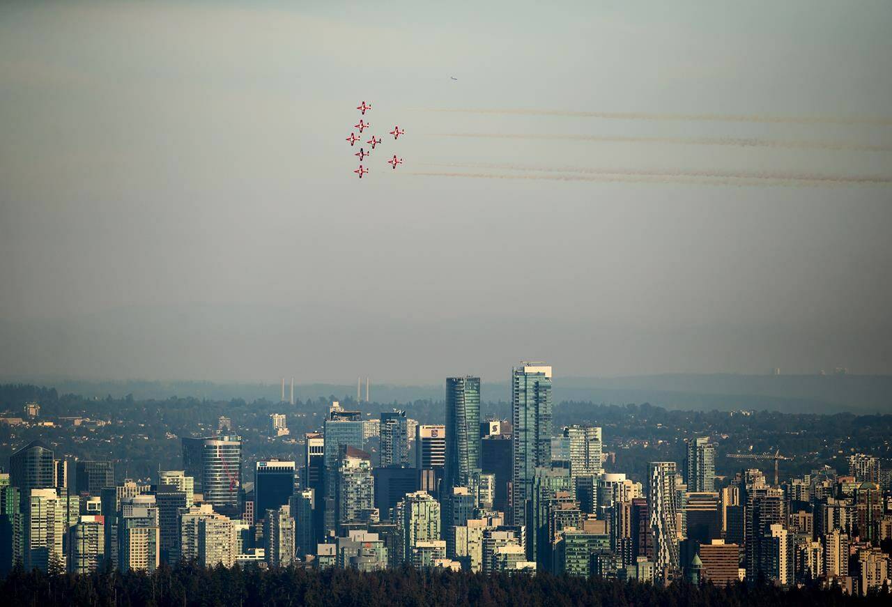 The Canadian Forces Snowbirds air demonstration team fly over the downtown skyline as part of the Celebration of Light fireworks festival, in Vancouver, on Wednesday, July 27, 2022. The Snowbirds have been cleared for take off after a crash in B.C. last month forced the military’s famed aerobatics team to cancel appearances at several airshows. THE CANADIAN PRESS/Darryl Dyck