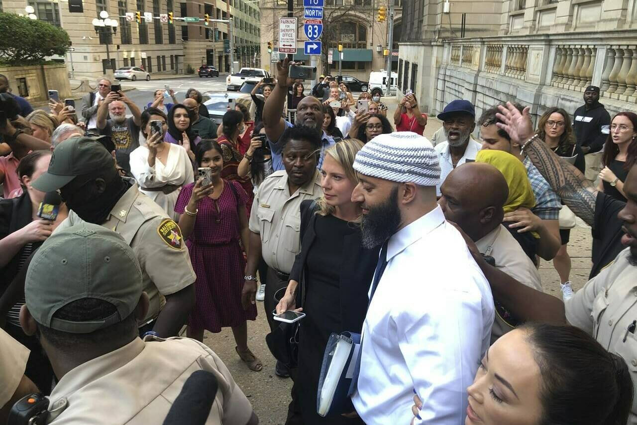 FILE — Adnan Syed, center, leaves the Cummings Courthouse on Sept. 19, 2022, in Baltimore. A judge has ordered the release of Syed on Tuesday, Oct. 11 after overturning his conviction for a 1999 murder that was chronicled in the hit podcast “Serial.” (AP Photo/Brian Witte, File)