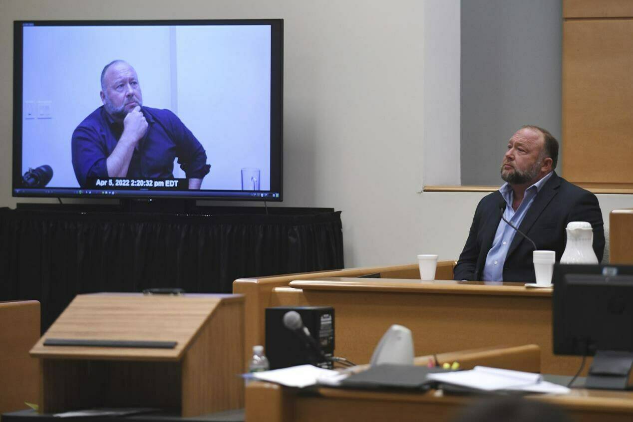 FILE - Infowars founder Alex Jones is shown a clip of his former deposition while testifying in the Sandy Hook defamation damages trial at Connecticut Superior Court in Waterbury, Conn. Thursday, Sept. 22, 2022. A Connecticut jury’s ruling that Jones pay $965 million to people he targeted with Sandy Hook lies is heartening to people disgusted by the muck of disinformation. Just don’t expect conspiracy theories to go away. (Tyler Sizemore/Hearst Connecticut Media via AP, Pool, File)