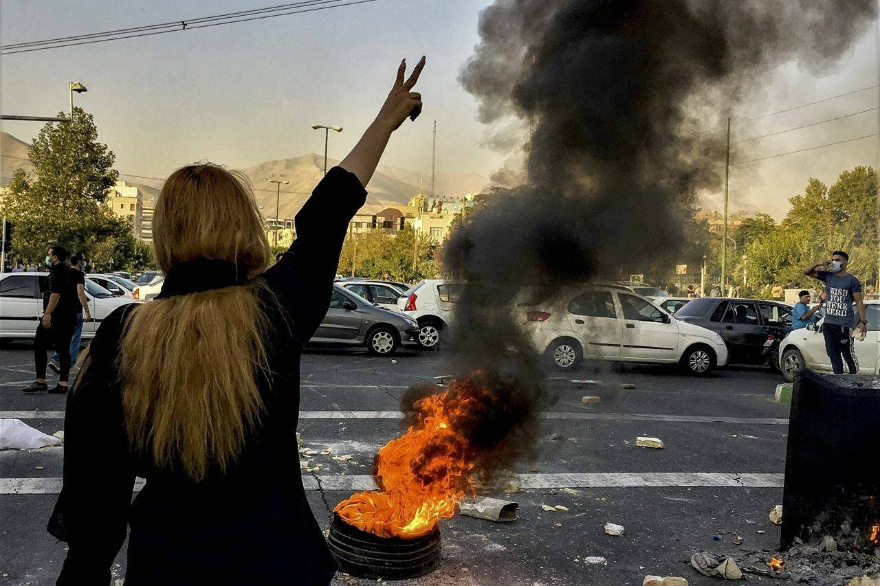 FILE - In this photo taken by an individual not employed by the Associated Press and obtained by the AP outside Iran, Iranians protests the death of 22-year-old Mahsa Amini after she was detained by the morality police, in Tehran, Oct. 1, 2022. As protests rage at home, Iran’s theocratic government is increasingly flexing its military muscle abroad. That includes supplying drones to Russia that now kill Ukrainian civilians, running drills in a border region with Azerbaijan and bombing Kurdish positions in Iraq. (AP Photo/Middle East Images, File)