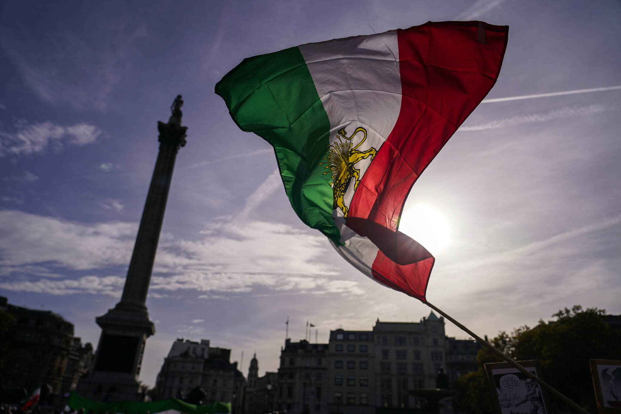 People wave a pre-islamic revolution Iran’s flag as they take part in a protest against Iranian authorities, in London, Saturday, Oct. 29, 2022. Protesters demonstrate to support doctors who are risking their lives treating people protesting in Iran in light of the death of Mahsa Amini, a 22-year-old woman died while in custody by Iran’s morality police. (AP Photo/Alberto Pezzali)