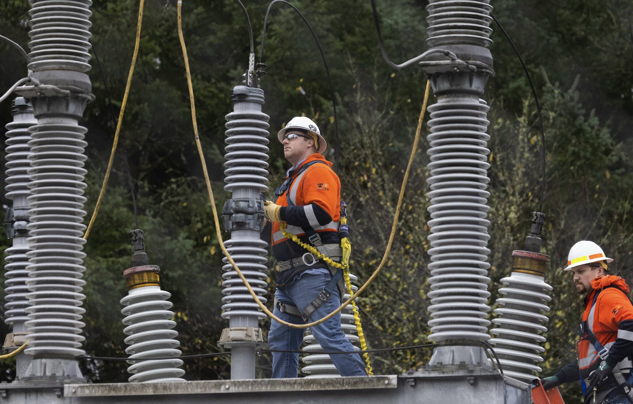 A power crew works at an electrical substation damaged by vandals. (Ken Lambert/The Seattle Times via AP)