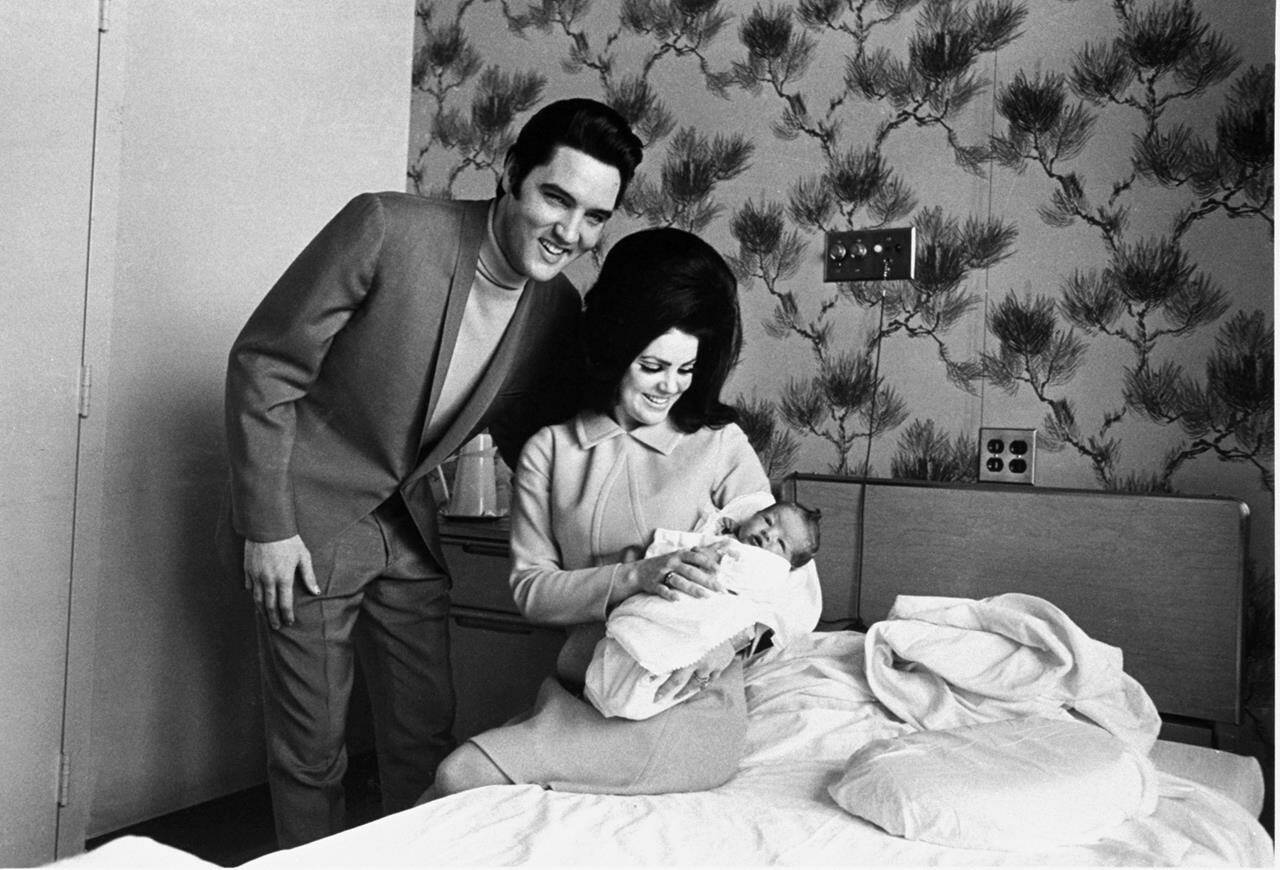 FILE - Lisa Marie Presley poses for her first picture, in the lap of her mother, Priscilla, on Feb. 5, 1968, with her father, Elvis Presley. Lisa Marie Presley — the only child of Elvis Presley and a singer herself — was hospitalized Thursday, Jan. 12, 2023, her mother said in a statement. (AP Photo/Perry Aycock, File)