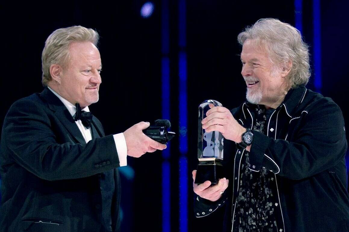 Randy Bachman (right) holds the Juno as Robbie Bachman videotapes a closeup of the trophy after being inducted into the Canadian Music Hall of Fame at the Juno Awards in Winnipeg, Sunday, March 30, 2014. Robbie Bachman, co-founder and drummer of Bachman-Turner Overdrive, has died at 69, representatives for his brother Randy confirm. THE CANADIAN PRESS/John Woods