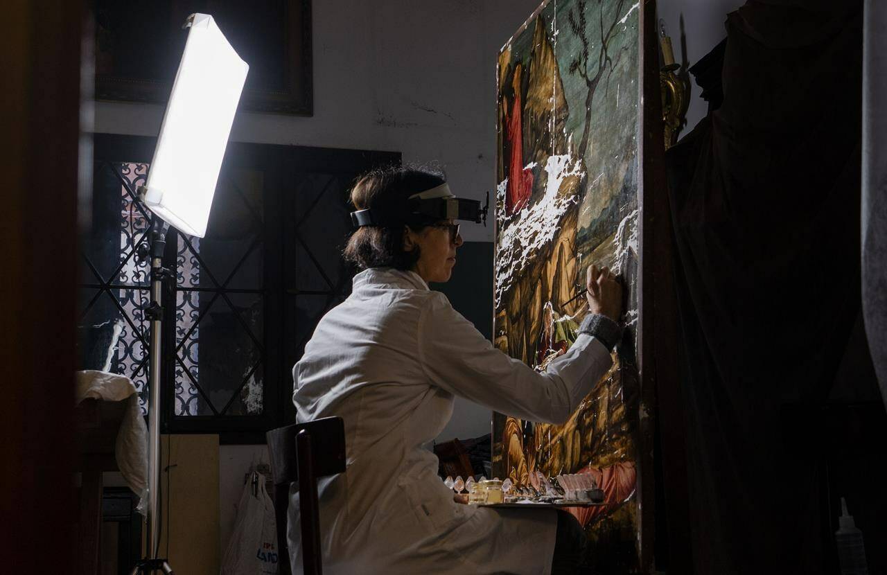 Restorer Valentina Piovan works on Vittore Carpaccio’s 1502 painting ‘The agony in the garden’ at the Dalmatian School in Venice, northern Italy, Wednesday, Dec. 7, 2022. On November 20th, the National Gallery of Washington inaugurated the first retrospective exhibition of Carpaccio’s works outside of Italy. It will run until February 12, 2023. (AP Photo/Domenico Stinellis)