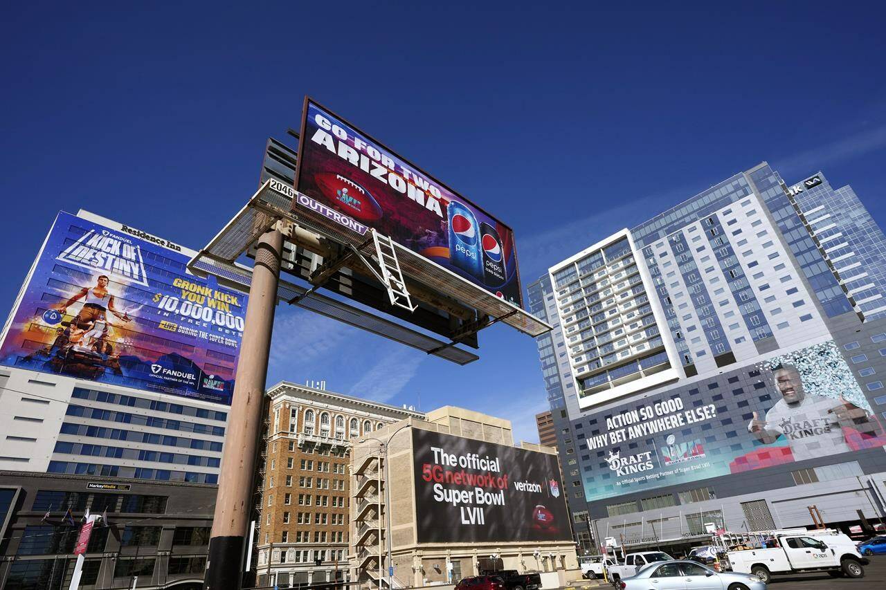 Large advertisements adorn buildings and electronic billboards leading up to the NFL Super Bowl LVII football game in Phoenix, Friday, Feb. 3, 2023. (AP Photo/Ross D. Franklin)