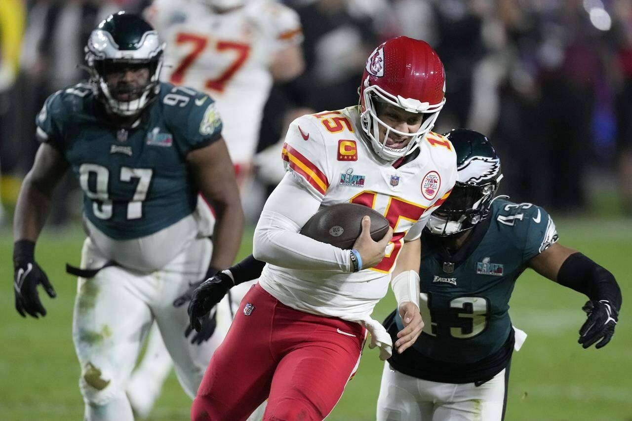 Kansas City Chiefs quarterback Patrick Mahomes (15) runs down field against Philadelphia Eagles linebacker Kyzir White (43) during the second half of the NFL Super Bowl 57 football game, Sunday, Feb. 12, 2023, in Glendale, Ariz. (AP Photo/Seth Wenig)