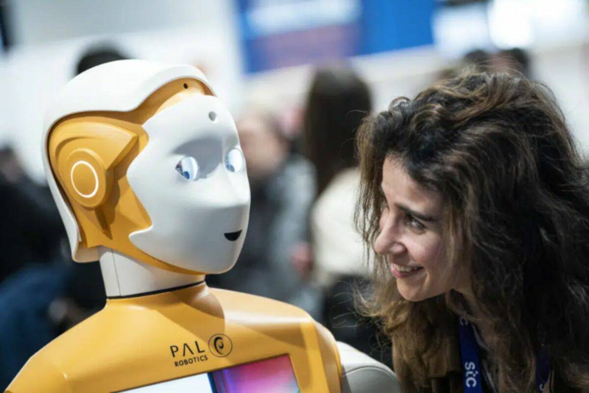 A visitor speaks with a PAL Robotic robot during the Mobile World Congress 2023 in Barcelona, Spain, on Wednesday, March 1, 2023. After three years of pandemic disruption, MWC, also known as Mobile World Congress, kicked off Monday in Barcelona, Spain, with mobile phone makers showing off new devices and telecom industry executives perusing the latest networking gear and software. (AP Photo/Joan Mateu Parra)