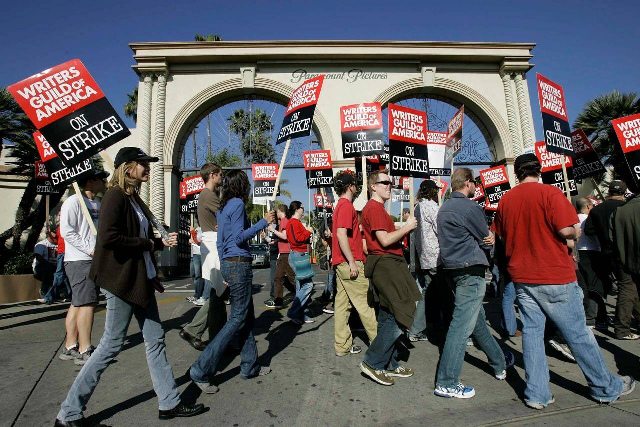 FILE - Striking writers walk the picket line outside Paramount Studios on Dec. 13, 2007, in Los Angeles. In an email to members Monday, April 17, 2023, leaders of the Writers Guild of America said nearly 98% of voters said yes to a strike authorization if a new contract agreement is not reached with producers. (AP Photo/Nick Ut, File)