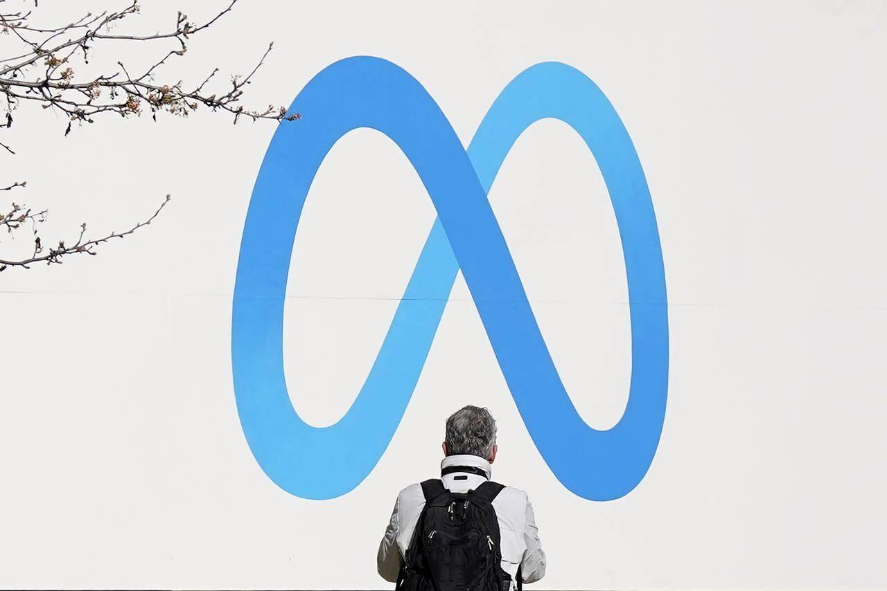 A person stands in front of a Meta sign outside of the company’s headquarters in Menlo Park, Calif., Tuesday, March 7, 2023. A representative for Meta says it has a team that is working toward blocking news for its Canadian users on Facebook and Instagram. THE CANADIAN PRESS/AP-Jeff Chiu