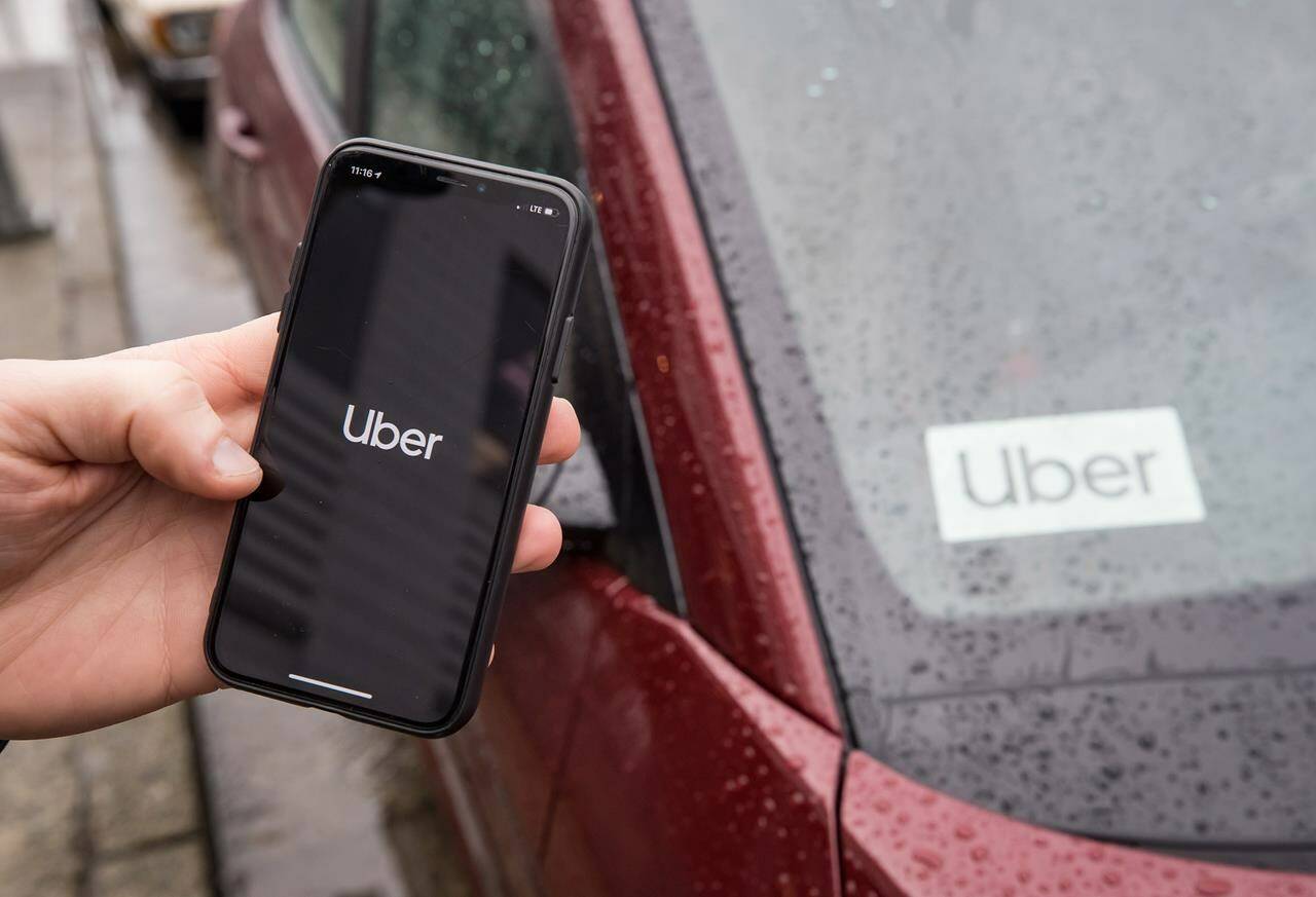 The Uber app is seen on an iPhone near a driver’s vehicle after the company launched service, in Vancouver, Friday, Jan. 24, 2020. Canadian teens will soon be able to hitch a ride through Uber. The tech giant says it will begin allowing people between the ages of 13 and 17 to make Uber accounts on the ride-hailing platform over the summer.THE CANADIAN PRESS/Darryl Dyck