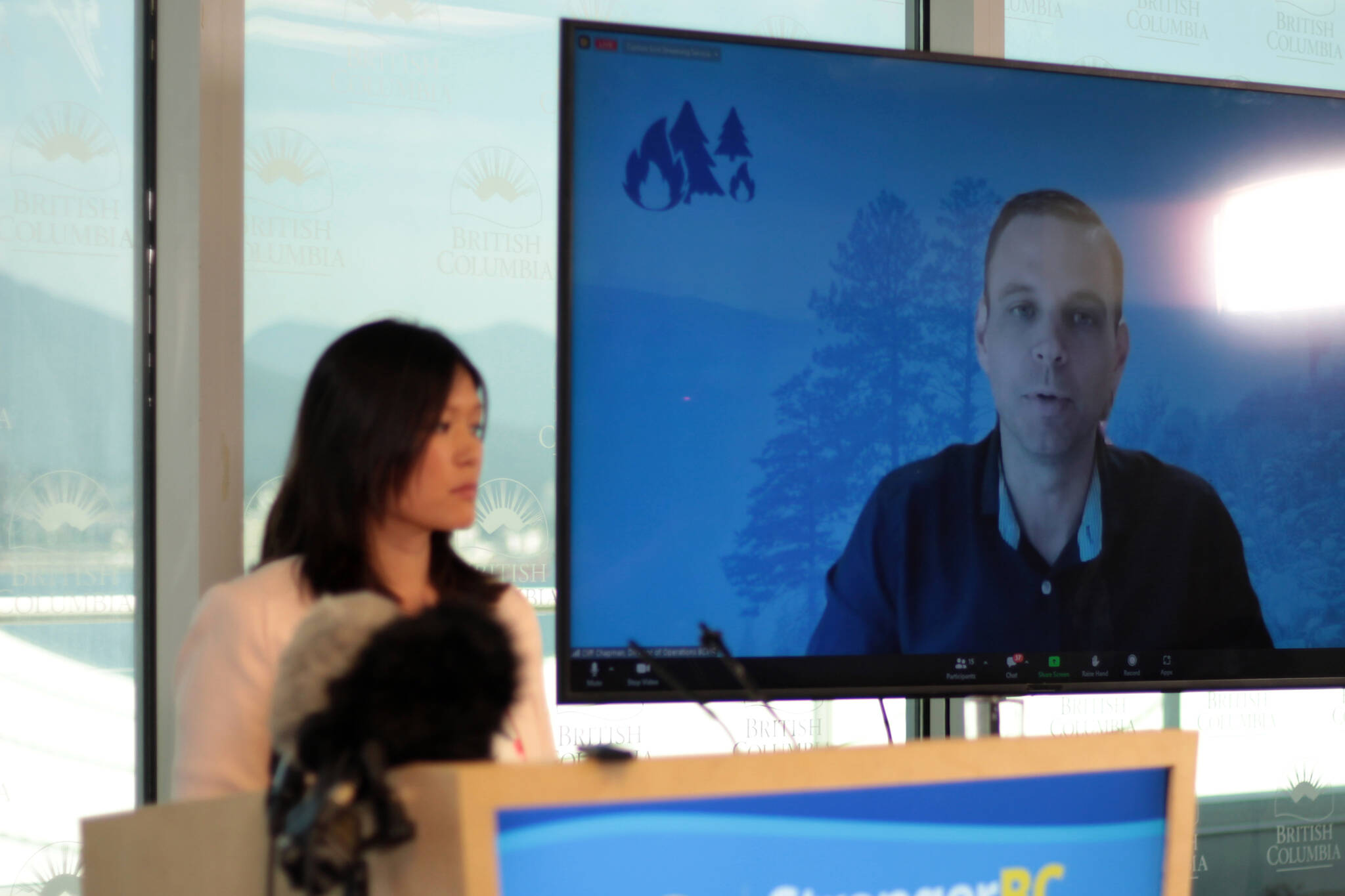 In Vancouver, Emergency Management Minister Bowinn Ma, left, looks on as BC Wildfire Service operations director Cliff Chapman speaks over Zoom June 8, 2023 in an update about the province’s wildfire situation. (Lauren Collins)