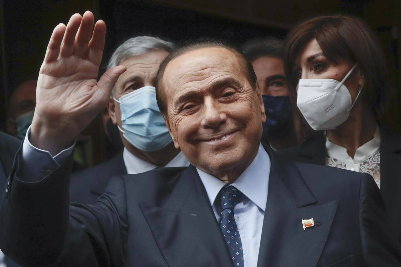 FILE - Former Italian Premier Silvio Berlusconi waves to reporters as he arrives at the Chamber of Deputies to meet Mario Draghi, in Rome, Feb. 9, 2021. Berlusconi, the boastful billionaire media mogul who was Italy’s longest-serving premier despite scandals over his sex-fueled parties and allegations of corruption, died, according to Italian media. He was 86. (AP Photo/Alessandra Tarantino, File)