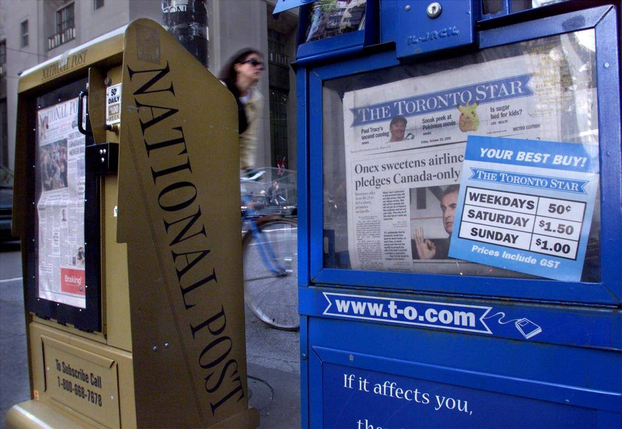 One expert says talks between Canada’s two largest newspaper chains about a potential merger are akin to a “Hail Mary pass” amid declining readership and advertising revenue. Toronto Star and National Post newspaper boxes are shown in downtown Toronto on Friday, October 29, 1999. THE CANADIAN PRESS/Kevin Frayer