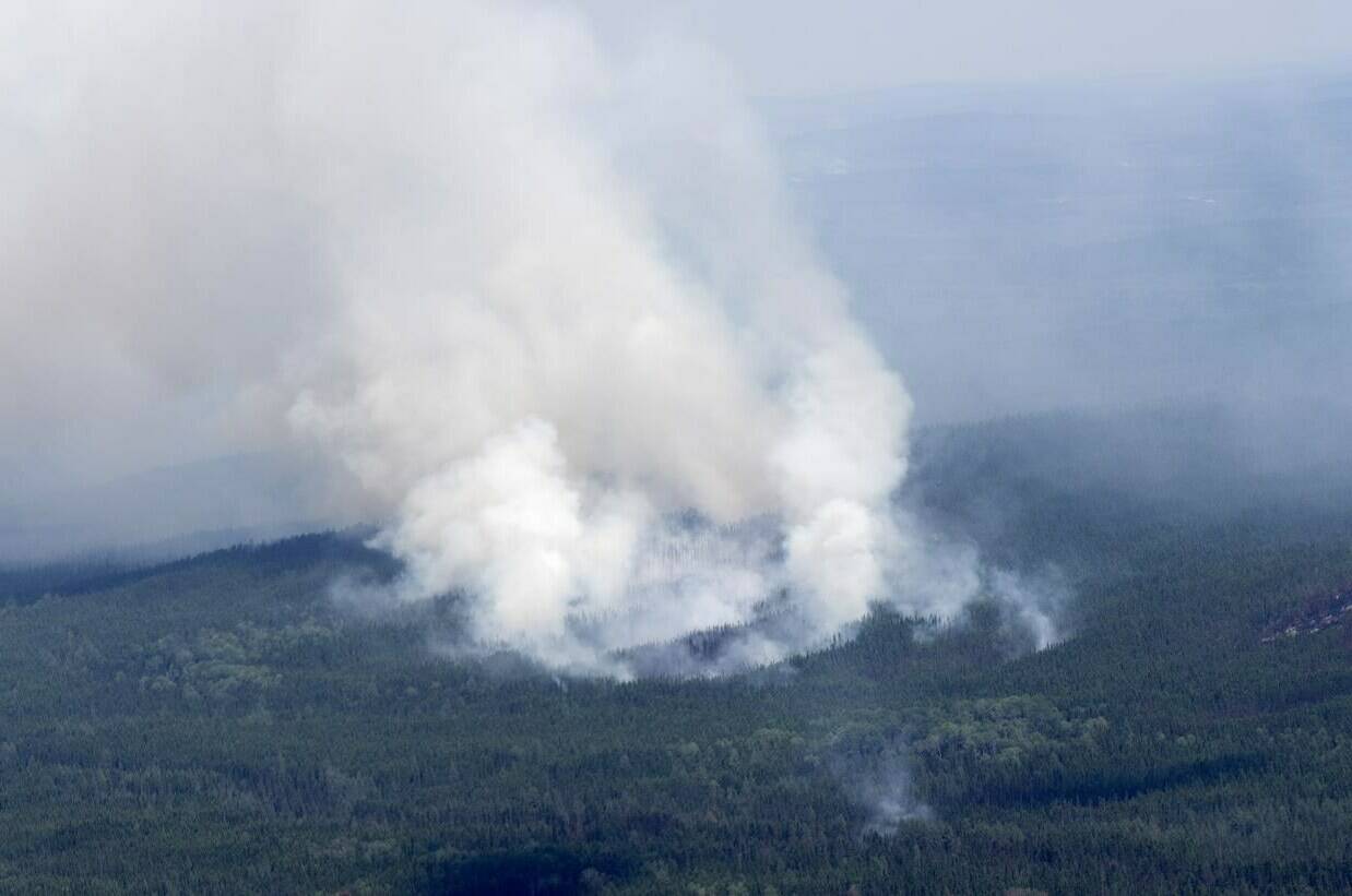 Ottawa is sending Canadian Rangers and deploying air assets to help with evacuations due to wildfires in northern Quebec. A smoke plume is seen rising from the forest south of Lebel-sur-Quevillon, Que., Wednesday, July 5, 2023. THE CANADIAN PRESS/Adrian Wyld