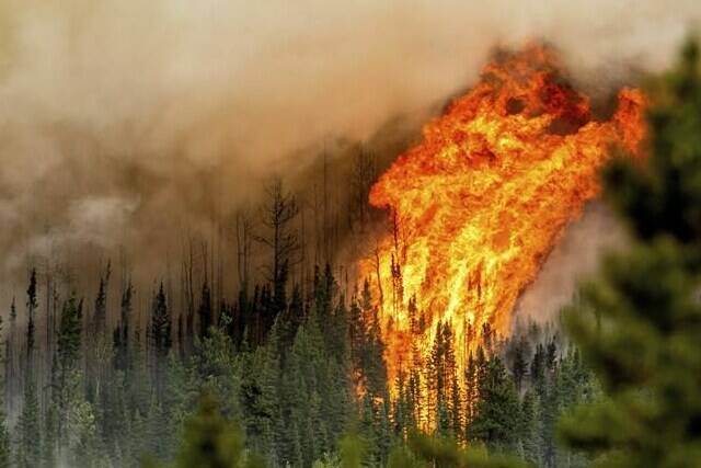 Flames from the Donnie Creek wildfire burn along a ridge top north of Fort St. John, B.C. on Sunday, July 2, 2023. Canada’s record-breaking wildfire season has now seen 100,000 square kilometres of land burned as fires continue to burn out of control across the entire country. THE CANADIAN PRESS/AP/Noah Berger