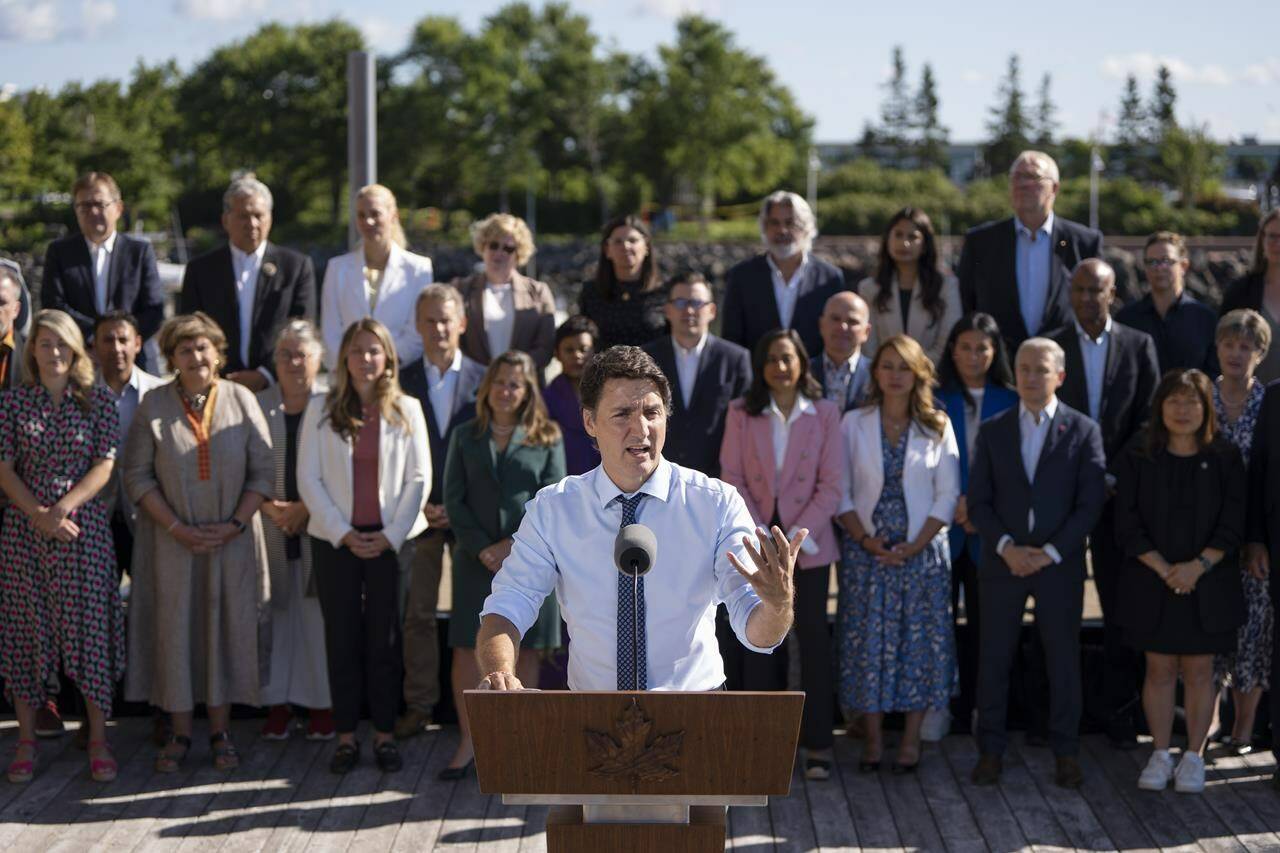Prime Minister Justin Trudeau speaks to reporters as cabinet members look on during the Liberal cabinet retreat in Charlottetown, P.E.I. on Wednesday, August 23, 2023. THE CANADIAN PRESS/Darren Calabrese