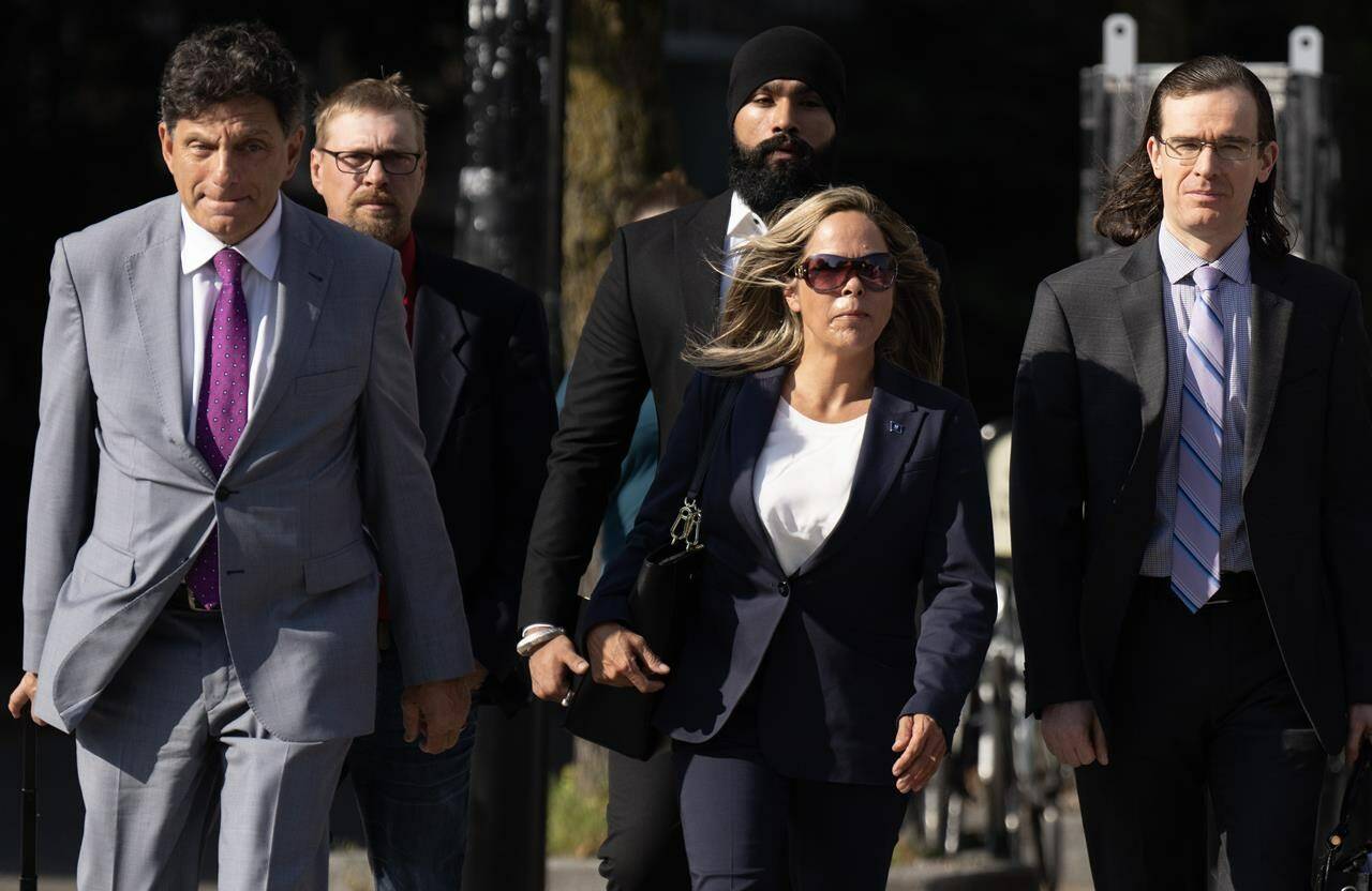 Lawyer Lawrence Greenspon (left) walks with Tamara Lich as they make their way to the courthouse on the first day of trial, in Ottawa, Tuesday, Sept. 5, 2023. The lawyers defending two of the most prominent organizers of the “Freedom Convoy” are expected to make their case today to block nine Ottawa residents and business representatives from taking the stand. THE CANADIAN PRESS/Adrian Wyld