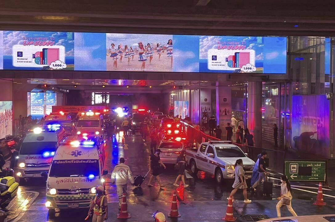 Ambulances wait outside an exit of the Siam Paragon Mall in Bangkok while shoppers rush out Tuesday, Oct. 3, 2023. Hundreds of shoppers fled the major shopping mall on Tuesday afternoon after what sounded like gunshots were heard inside. It was not immediately clear if shots had been fired, though police said there were injuries and some frightened shoppers were still hunkering down inside the mall. (AP Photo/Tian Macleod Ji)