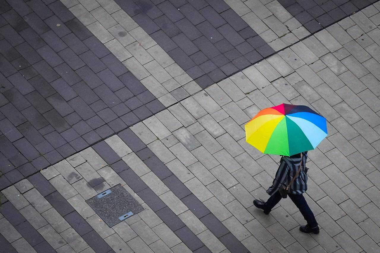 Much of British Columbia’s south coast is bracing for stormy weather as Environment Canada says a “potent and impactful” storm will bring heavy rain. A pedestrian carries an umbrella as light rain falls in Surrey, B.C., on Friday, October 21, 2022. THE CANADIAN PRESS/Darryl Dyck