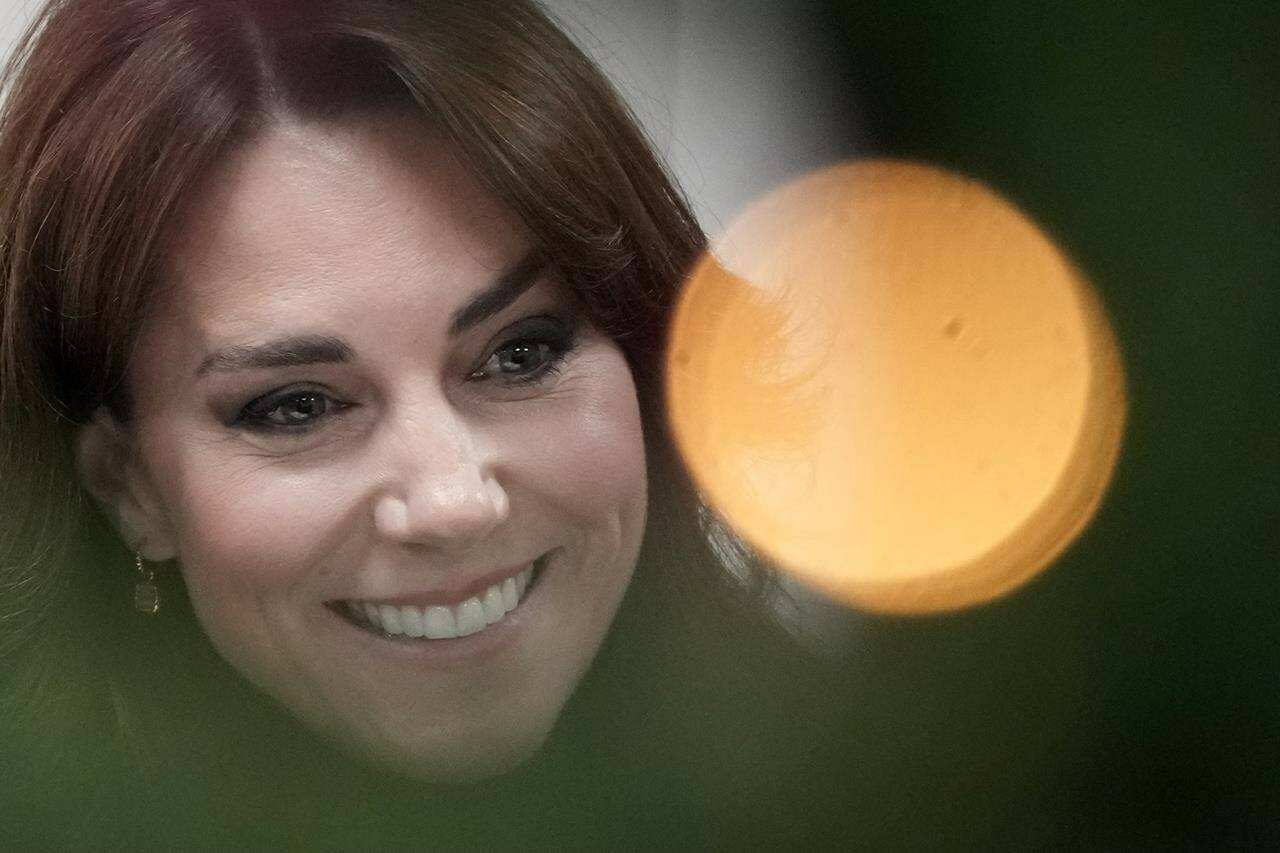 FILE - Kate, Princess of Wales, is seen behind a Christmas tree decorations as talks to people during her visit to Sebby’s Corner in north London, Friday, Nov. 24, 2023. Kate, Princess of Wales, has been discharged Monday, Jan. 29, 2024 from a London hospital and is making “good progress” after abdominal surgery. (AP Photo/Frank Augstein, Pool)