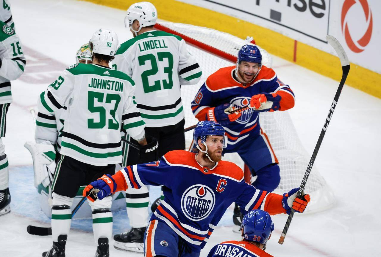 Dallas Stars forward Wyatt Johnston (53) and defenceman Esa Lindell (23) look away as Edmonton Oilers forward Connor McDavid (97) celebrates his goal with teammate forward Zach Hyman (18) during first period of Game 6 of the Western Conference final of the NHL hockey Stanley Cup playoffs in Edmonton, Sunday, June 2, 2024.THE CANADIAN PRESS/Jeff McIntosh